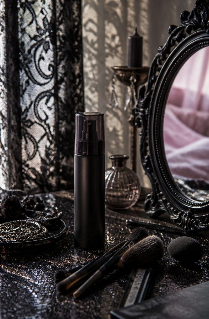 L'Oréal Paris Infallible Setting Spray next to an antique mirror.